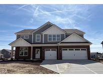 Two-story home featuring a two-car garage, brick accents, and gray siding under a blue sky at 1260 Thornwood Dr, Greenwood, IN 46143