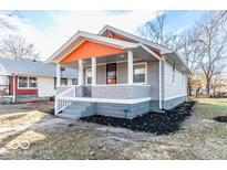 Charming bungalow featuring a well-manicured lawn and covered front porch, perfect for enjoying the outdoors at 1302 S Sherman Dr, Indianapolis, IN 46203