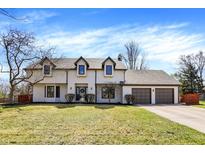 Charming two-story home featuring a three-car garage, manicured lawn, and classic curb appeal at 13125 Tudor Dr, Carmel, IN 46033