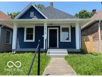 Charming blue home with a covered front porch, white pillars, and walkway at 1518 Lawton Ave, Indianapolis, IN 46203