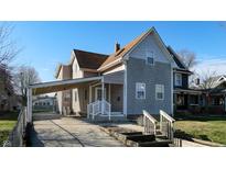 Charming two-story home with a covered parking area and a well-maintained front yard at 1521 Pleasant St, Indianapolis, IN 46203