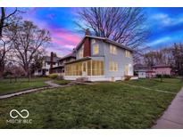 Two-story home with screened-in porch and brick chimney, set on a well-manicured lawn at 3601 Carrollton Ave, Indianapolis, IN 46205