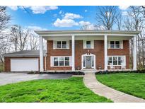 Charming two-story brick home boasts a welcoming front porch with elegant white columns at 40 Twinshore Ct, Carmel, IN 46033