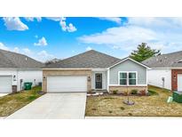 Charming single-Gathering home with a well-maintained lawn, a two-car garage, and a mix of vinyl and brick exterior accents at 4205 Ashton Vw Ln, Indianapolis, IN 46268
