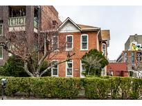 Charming red brick house with white trim, surrounded by lush green hedges and a tree at 424 E Vermont St, Indianapolis, IN 46202