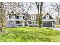Charming two-story home featuring stone accents, gray siding, and a well-manicured lawn at 4915 E 79Th St, Indianapolis, IN 46250