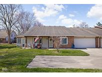Charming single story home featuring an attached two car garage and a well maintained front yard at 7349 Castleton Farms N Dr, Indianapolis, IN 46256