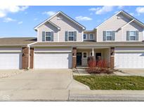 Inviting townhome featuring a two-car garage, charming curb appeal, and a classic facade with stylish accents at 9694 Angelica Dr, Noblesville, IN 46060