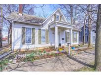Charming two-story home features a well-manicured front yard and inviting front porch at 110 E Hendricks St, Shelbyville, IN 46176