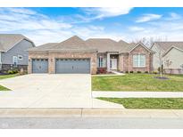 Charming brick home featuring a three-car garage, well-manicured lawn, and inviting curb appeal at 11598 Platt St, Noblesville, IN 46060