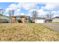Charming single-story brick home featuring a two-car garage and a well-maintained front yard at 1330 N Gibson Ave, Indianapolis, IN 46219