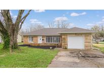 Charming single Gathering home featuring a stone facade, attached garage, and well-maintained front yard at 220 Monroe St, Indianapolis, IN 46229