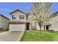 Charming two-story home with brick and vinyl siding, featuring a well-manicured lawn and blooming tree at 2468 Shadow Bend Dr, Columbus, IN 47201