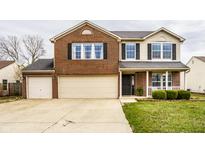 Inviting two-story brick home featuring an attached two-car garage and well-manicured front lawn at 305 Beacon Point Ln, Fortville, IN 46040