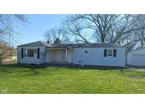 Exterior of a single-story home with an attached garage, front lawn and large trees at 318 Chester St, Anderson, IN 46012