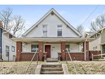 Charming two-story home featuring a front porch with brick accents and updated details at 412 N Riley Ave, Indianapolis, IN 46201