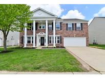 Traditional two-story brick home with stately white columns and a well-manicured lawn at 5565 Noble Dr, Indianapolis, IN 46234