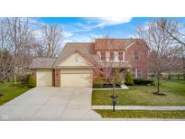 Traditional brick home featuring an attached two-car garage and a well-manicured front lawn at 6124 Salisbury Ln, Noblesville, IN 46062