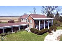 An exterior view showing the red brick, columned front, and landscaped lawn at 7180 N State Road 42, Eminence, IN 46125