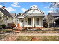 Charming white house featuring a brick foundation, covered porch, and exquisite architectural details at 724 Lafayette Ave, Columbus, IN 47201