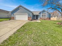 Charming blue ranch home with a well-manicured lawn, attached two-car garage, and brick accents at 1066 Laura Dr, Greenwood, IN 46143