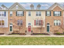 Townhomes with brick and siding, green doors, and manicured lawns in a well-maintained community at 12683 White Chapel Cir, Fishers, IN 46037