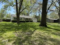 Charming single-story home with a well-manicured lawn and mature trees, creating a serene curb appeal at 2843 Canterbury Ln, Indianapolis, IN 46220