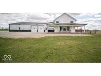 Charming white farmhouse with a large front porch and a spacious detached garage at 2968 W Old Franklin Rd, Shelbyville, IN 46176