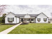 Charming home with white siding, black shutters, a manicured lawn, and inviting front porch at 311 2Nd Ne St, Carmel, IN 46032