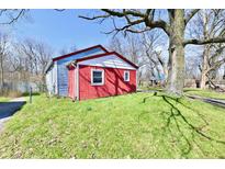 View of the home with red and blue siding sitting on a green lawn at 3142 N Euclid Ave, Indianapolis, IN 46218