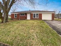 Charming one-story brick home featuring an attached garage and well-maintained front lawn at 3662 Lombardy Pl, Indianapolis, IN 46226