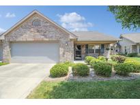 Charming brick home with a manicured front yard and attached garage on a sunny day at 4043 Oak Trail Dr, Indianapolis, IN 46237