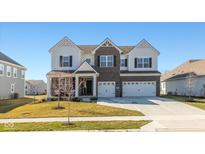 Beautiful two-story home with brick and siding, a three-car garage, and a well-manicured lawn at 5387 Citadel Dr, Noblesville, IN 46062