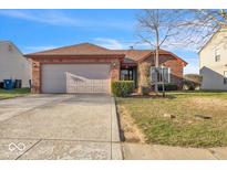 Charming brick home featuring a two-car garage and well-maintained lawn at 6678 Colleens Way, Indianapolis, IN 46221