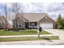 Inviting single-Gathering home with a well-manicured lawn and an attached two-car garage at 9752 Brook Wood Dr, McCordsville, IN 46055