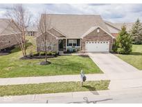 Inviting single-Gathering home with a well-manicured lawn and an attached two-car garage at 9752 Brook Wood Dr, McCordsville, IN 46055
