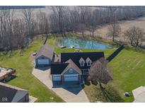 Stunning aerial view of home with large pond, dock, in-ground pool, and three-car garage at 1471 S Frog Pond Ct, Greenfield, IN 46140