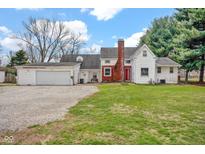 Charming home with a red front door, brick accents, and a spacious two-car attached garage at 1707 Rocky Ford Rd, Columbus, IN 47203