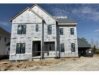 New construction home featuring black window frames and wrapped in styrofoam insulation under a cloudy, blue sky at 20598 Chatham Creek Dr, Westfield, IN 46074