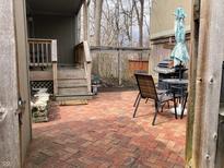 Brick patio with outdoor dining set and grill, perfect for entertaining in the backyard at 4214 Woodsage Trce, Indianapolis, IN 46237