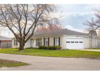 Charming brick ranch home with an attached two-car garage and a well-manicured front yard at 4690 Northeastern Blvd, Columbus, IN 47203