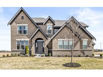 Charming, two-story brick home featuring manicured landscaping and a welcoming entrance at 4763 Denton Dr, Zionsville, IN 46077