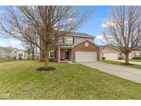 Two-story home featuring a brick facade, gray siding, well-maintained lawn, and a two-car garage at 6916 Cobb Cir, Noblesville, IN 46062
