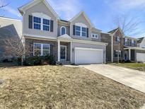 Charming two-story home with gray siding, stone accents, well-manicured lawn, and attached garage at 733 Keepsake Run, Greenwood, IN 46143