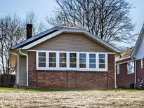 Charming single-story home featuring a brick foundation and a row of windows at 917 N Graham Ave, Indianapolis, IN 46219
