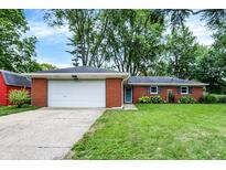 Charming brick home featuring a well-manicured lawn and attached two-car garage at 917 Stockton St, Indianapolis, IN 46260