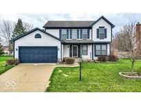 Charming two-story home featuring a landscaped yard, blue shutters, and a two-car garage at 12555 Wolford Dr, Fishers, IN 46038
