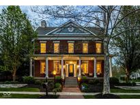 Charming two-story brick home with a welcoming front porch, columns, and landscaped front yard at 12897 Queens Troop, Carmel, IN 46032