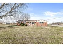 Charming single-story brick home with a well-maintained front lawn and beautiful landscaping under a clear blue sky at 1636 N County Road 425 E, Avon, IN 46123