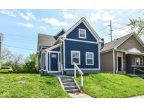 Charming blue two-story home with landscaped front yard and inviting entryway on a sunny day at 1653 S Delaware St, Indianapolis, IN 46225